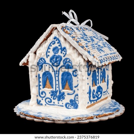Christmas decoration snow house made from gingerbread dough decorated with icing, holiday decoration isolated on black background selective focus close-up