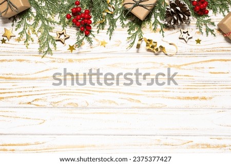 Rustic style Christmas and New Year border with gift boxes and traditional decorative elements on white wooden background with copy space for your design.
