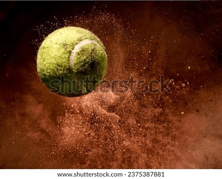 Flying tennis ball in explosion of red dust, close up Royalty-Free Stock Photo #2375387881