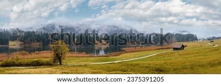 Alpine  lake Geroldee or Wagenbruchsee, Bavaria, Germany. Autumn overcast, foggy and drizzle day. Picturesque traveling, seasonal, weather, and rural nature beauty concept scene. Royalty-Free Stock Photo #2375391205