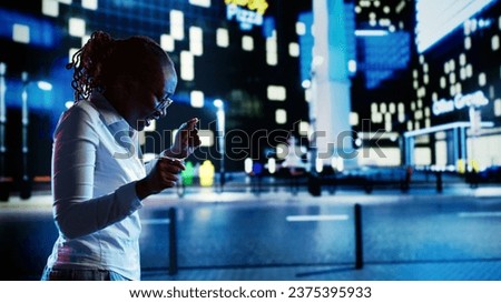 African american businesswoman prancing around in empty city streets during nighttime, feeling happy after receiving promotion at work. Jubilant woman enjoying herself while wandering on boulevard