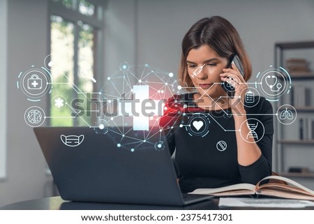 Pensive attractive beautiful businesswoman working on laptop, talking on phone at office workplace in background. Flying medical icons. Concept of health care and insurance.