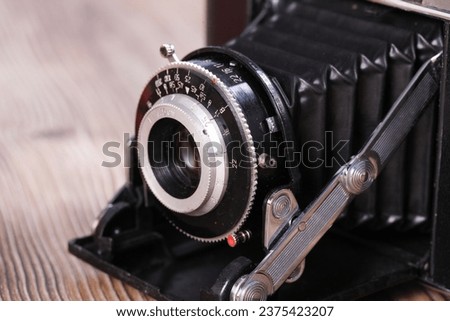 Antique film folding camera and old film, close-ups
