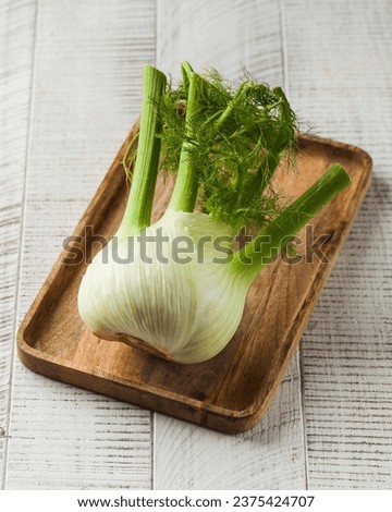 Ripe fresh fennel on a wooden board on a white background. healthy eating.
