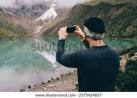male traveller taking pictures of nature via mobile