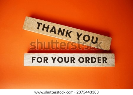 The words Thank you for your order are engraved on the surface of the wooden block on an orange background. Business concept, small business.