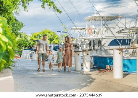 A happy, mature couple over 40 with their two daughters enjoying a leisurely walk on the waterfront, their joy evident as they embrace the journey of pregnancy later in life Royalty-Free Stock Photo #2375444639