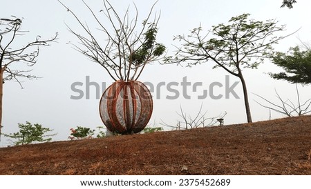 iron frame shaped like a yellow pumpkin in a park