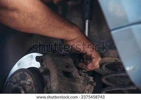 Close up Car Mechanic man hands repairing car auto repair shop. Man hands fixing machinery vehicle mechanical service. open vehicle hood checking up auto mobile. Vehicle Car maintenance engineer.