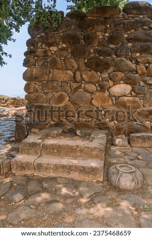 Throne platform at Tel Dan Israelite Gate, used by a king settling legal cases. Circular stone vases held wooden posts that supported a canopy. A standing stone to the left represents a deity. Royalty-Free Stock Photo #2375468659