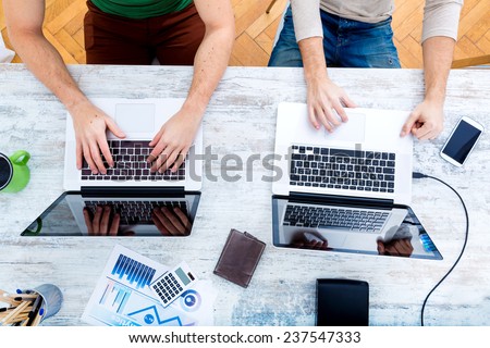 Two workmates teaming up and working together.  Royalty-Free Stock Photo #237547333