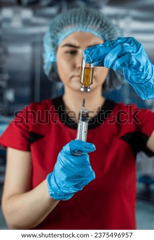 Caucasian healthcare worker woman nurse with   syringe and ampoule, preparing vaccine.  Medicine and drug concept.