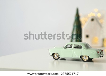 Green car with New Year's decoration on the background.