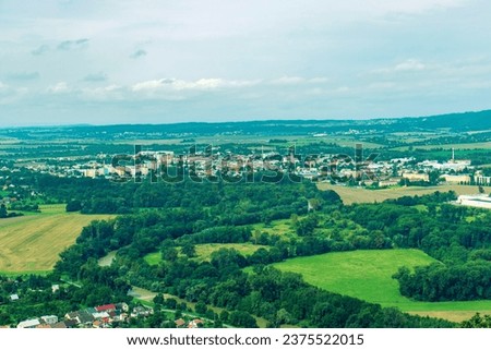 An abstract photograph of the nature of the Czech Republic captured from an observation tower. Horizon, landscape shot. Lowland village, forests, meadows, village, city, blue sky, clouds.