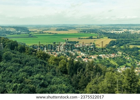 An abstract photograph of the nature of the Czech Republic captured from an observation tower. Horizon, landscape shot. Lowland village, forests, meadows, village, city, blue sky, clouds.