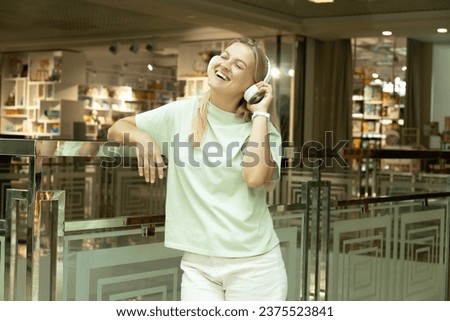 A young woman listens to music in headphones