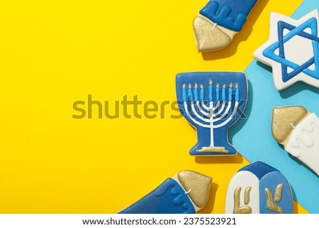 Gingerbread cookies with Jewish symbols on yellow background, space for text
