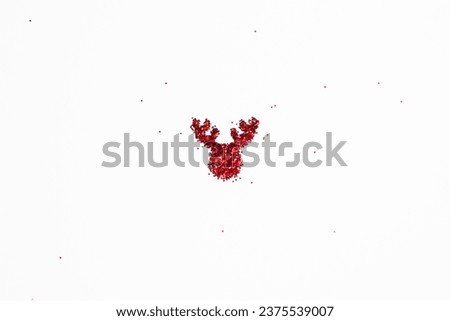 The shape of a reindeer's head of shiny colorful red glitter on white background with copy space,