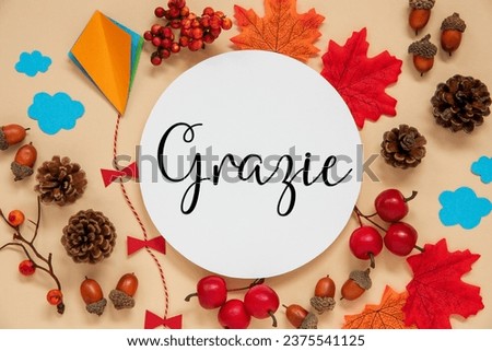 Fall Decoration, Colorful Autumn Leaves and Handicraft Kite, Round Label With Italian Text Grazie, Which Means Thanks In English