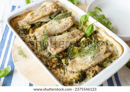 Baked fish fillets with creamy brown rice and broccoli in a baking dish