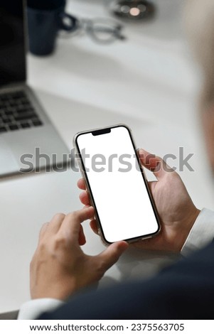Close up man using smartphone at office desk. Empty screen for your advertising text message.