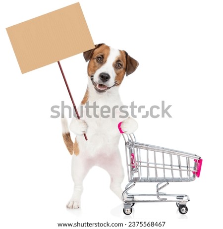 Jack russell terrier puppy pushing a shopping cart and showing empty placard. isolated on white background.