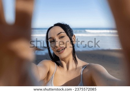 pretty sporty woman doing selfie on tourist beach