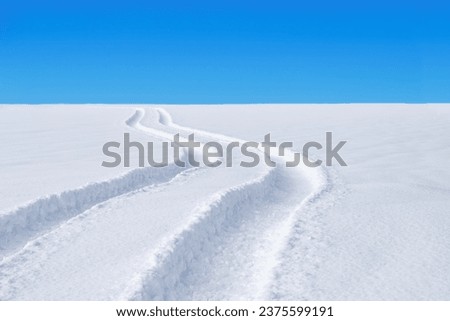Car tracks in the deep fresh snow. winter landscape. Royalty-Free Stock Photo #2375599191