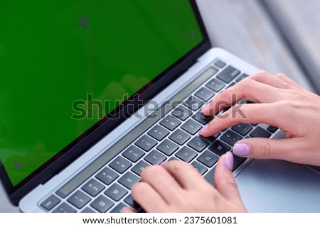 Business lady surfing the internet on a laptop with a green screen.