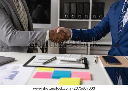 Two colleagues after signing the contract Businessmen shaking hands after signing a contract in a bright sunny modern office close-up Business communication, handshake and marketing concept.