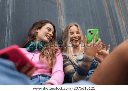 Young stylish generation Z girls spending time outdoors after school. Zoomer students talking and gossiping during lunch break in the school. Importance of education for gen Z. Royalty-Free Stock Photo #2375615121