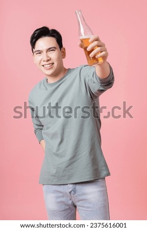 Photo of young Asian man drinking alcohol on background Royalty-Free Stock Photo #2375616001