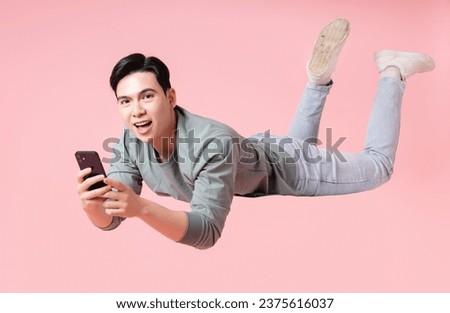 Photo of young Asian man flying on background Royalty-Free Stock Photo #2375616037