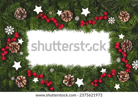 Christmas Border frame of tree branches on white background with copy space isolated, red and white decor, berries, stars, cones