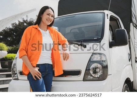 Photo of young Asian woman with her truck