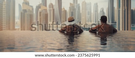 couple enjoying panorama view of Dubai marina from infinity pool. UAE travel. banner copy space Royalty-Free Stock Photo #2375625991