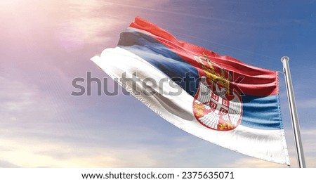Serbia national flag waving in beautiful sky. The flag waving with dynamic angle.