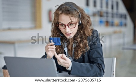Young woman business worker having video call holding credit card at the office