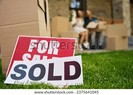 Signs for sale, sold on a green lawn