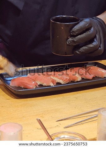 The chef is making tuna sushi.