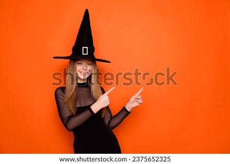 Photo of charming beautiful conjurer teenager girl indicate fingers empty space ad isolated on orange color background