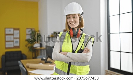 Young blonde woman architect smiling confident standing with arms crossed gesture at office