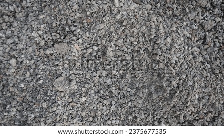 Gray small rocks ground texture. black small road stone background. gravel pebbles stone seamless texture, marble. dark background of crushed granite gravel, close up. grey clumping clay. flat view