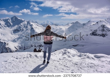Girl on the background of snow-capped mountains. Caucasian mountains. Elbrus. Russia. April 25, 2019