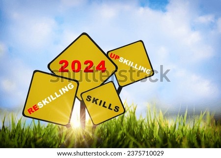 2024 new year upskilling, reskilling and skills written on yellow sign on grasses on sky background. Future ahead success with education concept and self development idea