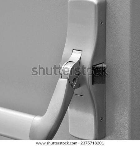 Emergency exit door. Closed up latch door handle of emergency exit. Push bar and rail for panic exit