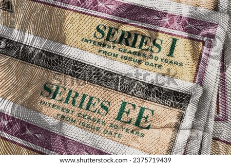 Series I and Series EE US Savings Bonds with 100 dollar bill overlay. Savings bonds are debt securities issued by the US. Royalty-Free Stock Photo #2375719439