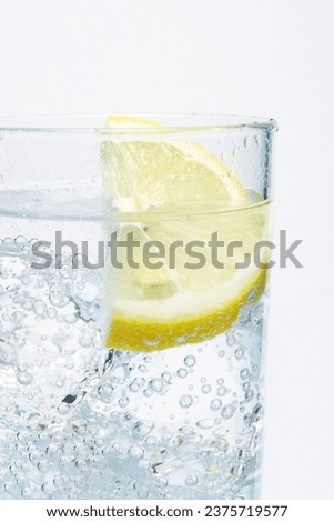 Highball glass with fizzy water and a slice of lemon on a white background Royalty-Free Stock Photo #2375719577