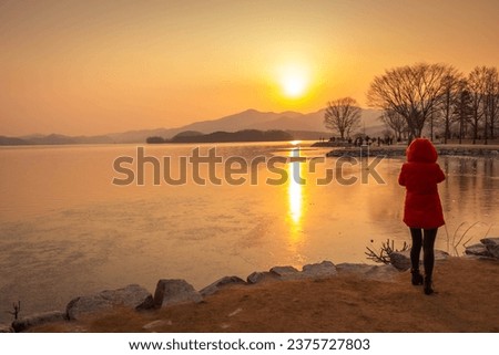 Tourists taking pictures of a frozen lake in South Korea in winter in sunset at Dumulmeori, Yangpyeong, South Korea.