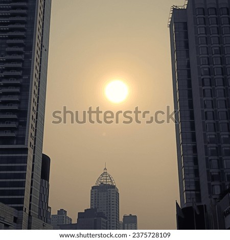 sunset view surrounded by buildings. The picture was taken in the evening around 4 or 5 p.m and it was near a place called Bundaran H.I in Indonesia